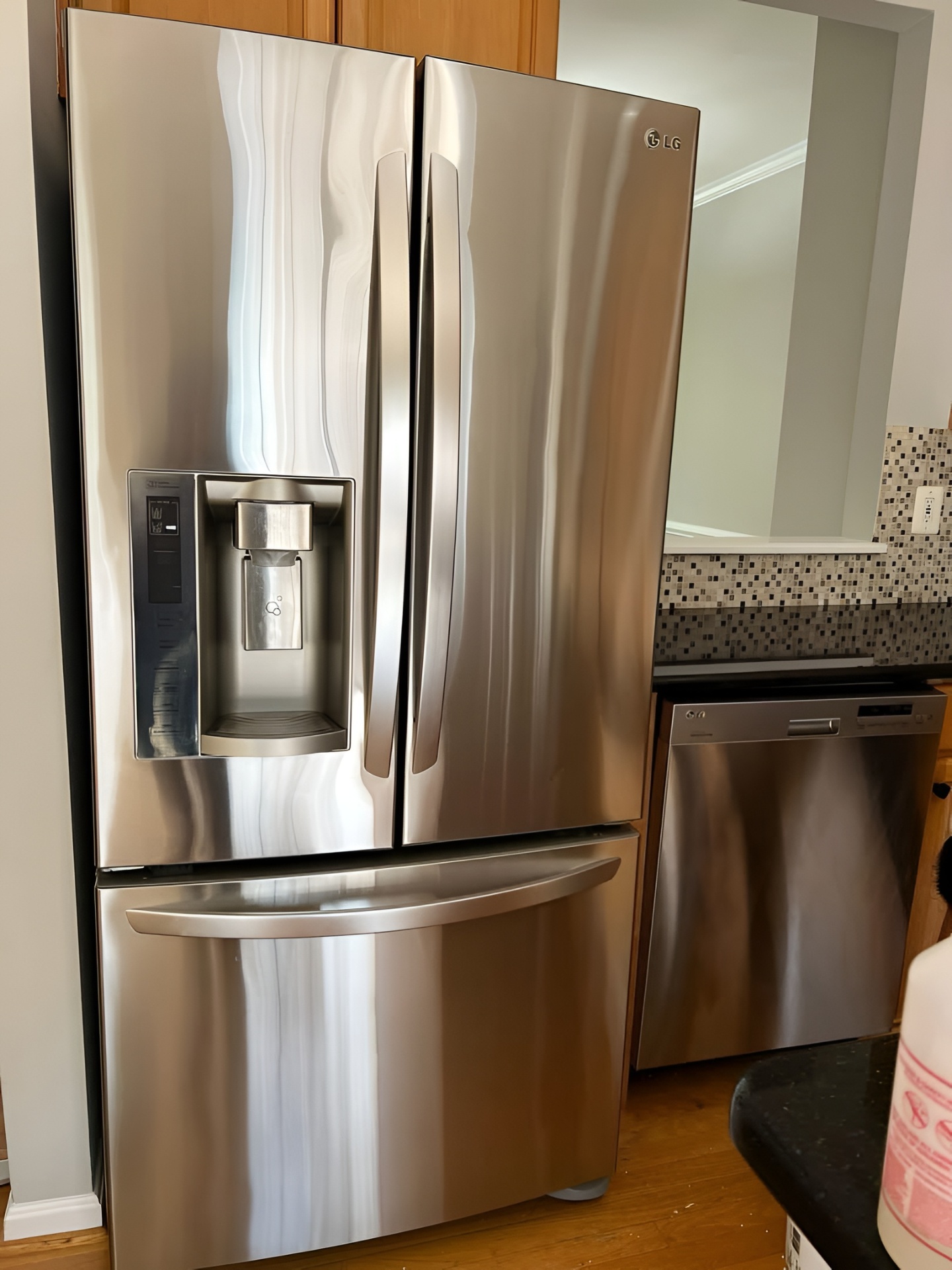Polished stainless steel refrigerator in a cleaned kitchen