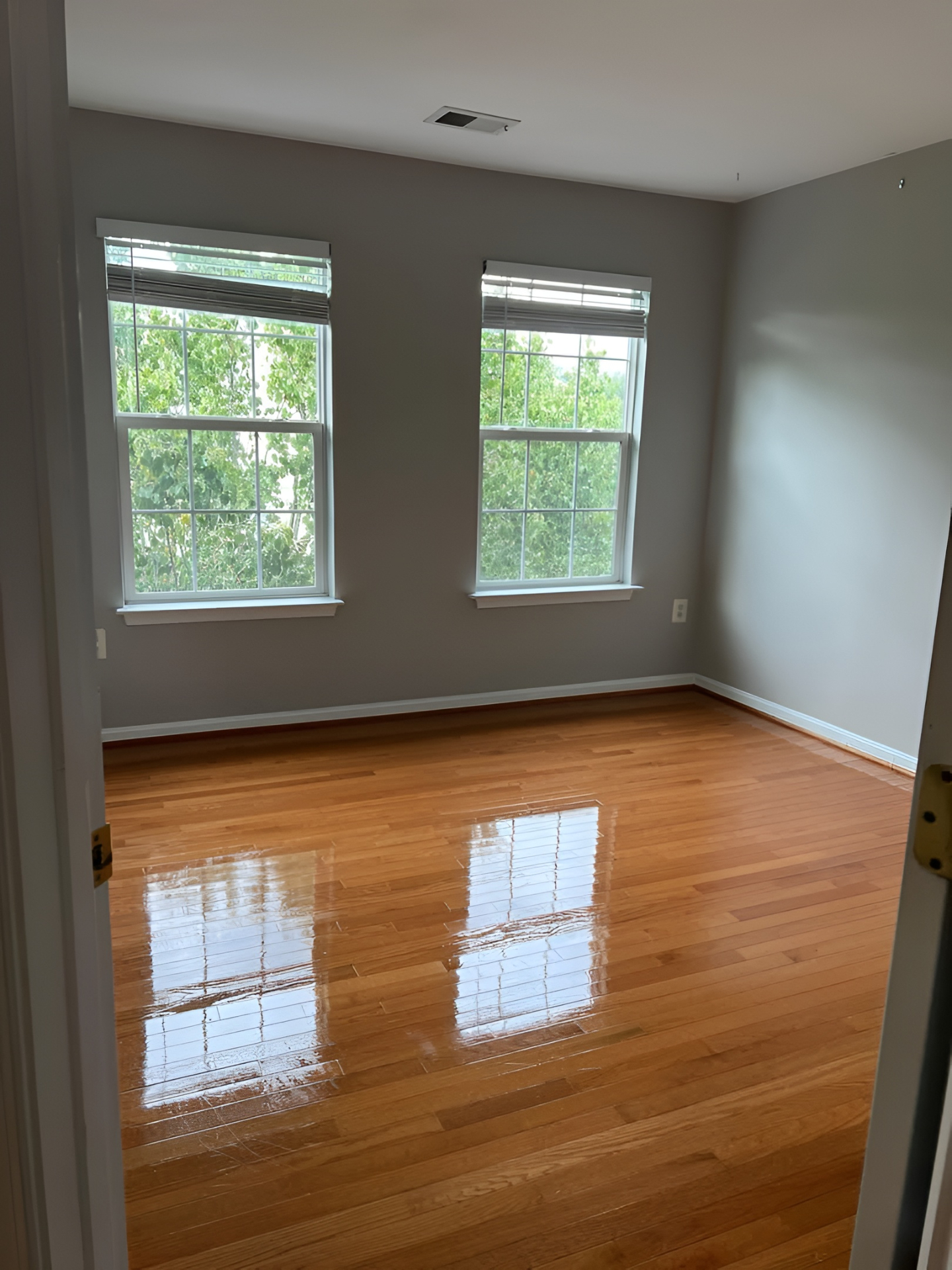 Room with polished hardwood floors after cleaning service